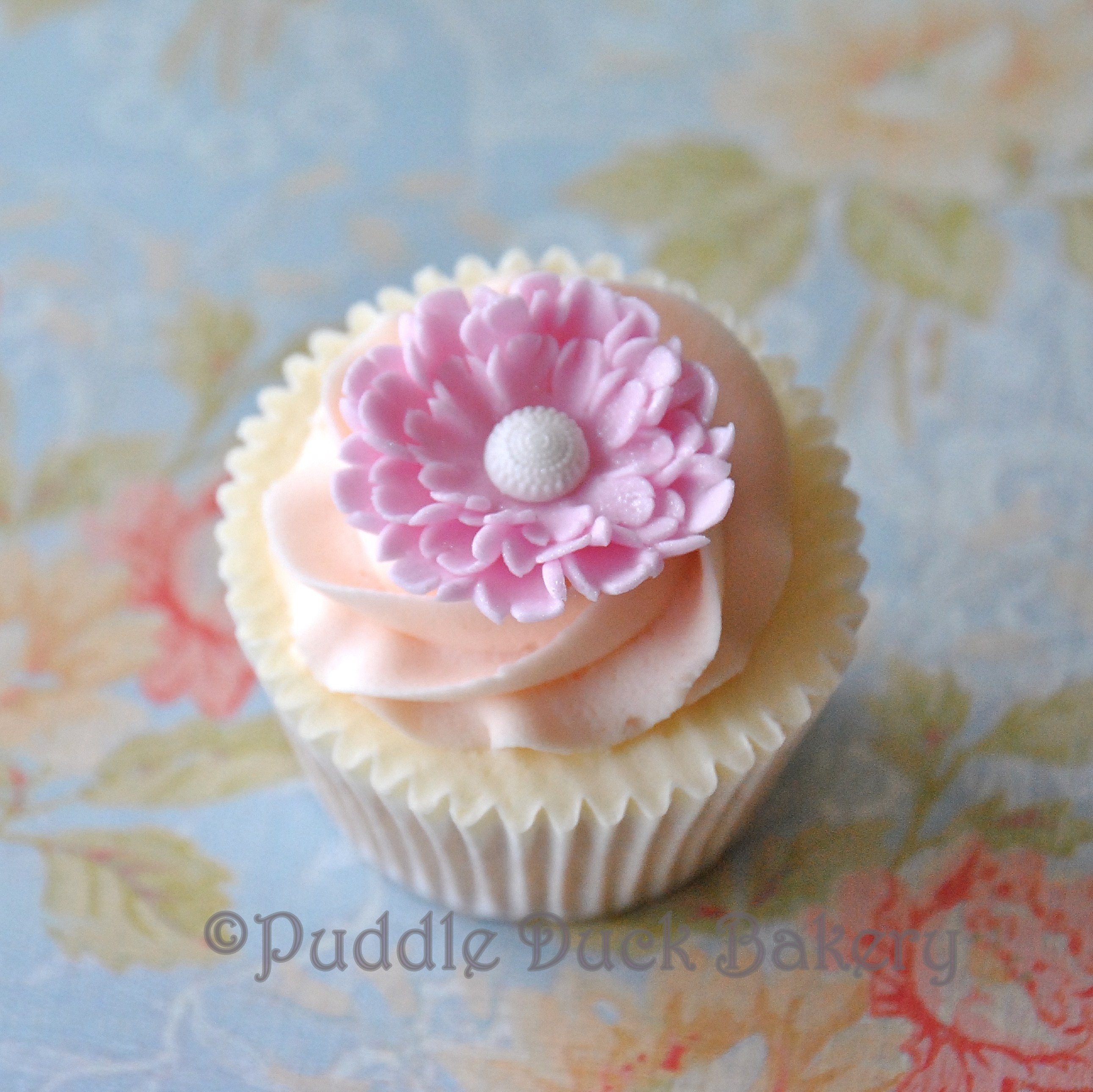 A swirl and a beautiful flower on a cupcake