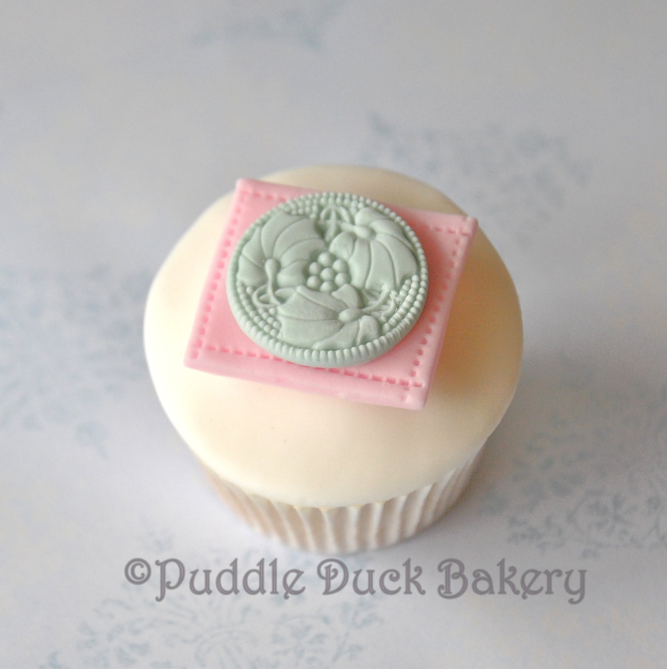 Using a stamp to decorate a button on a cupcake