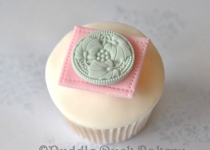 Using a stamp to decorate a button on a cupcake