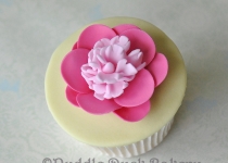 A pink flower on a cupcake